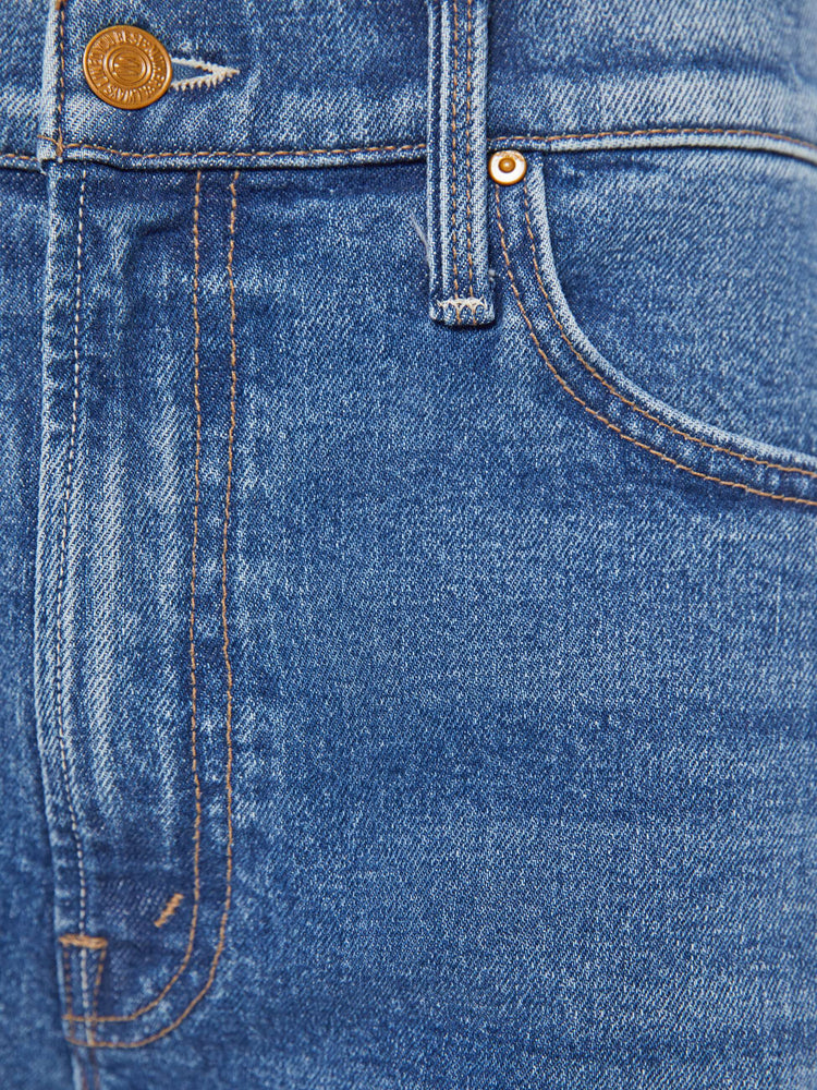 Swatch view of a woman in a mid blue jeans designed to sit lower on the hips with a zip fly, loose wide leg and a clean ankle-length inseam. 