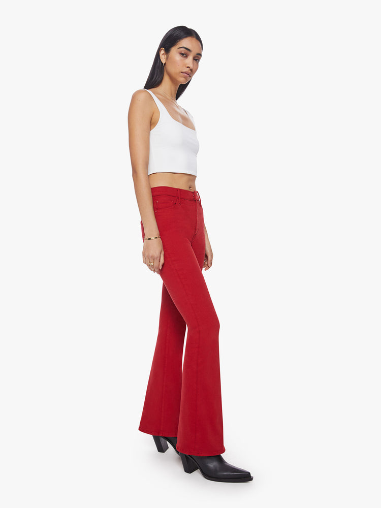 Side angle view of a bright red hue flare has a high rise, long 31-inch inseam and clean hem.