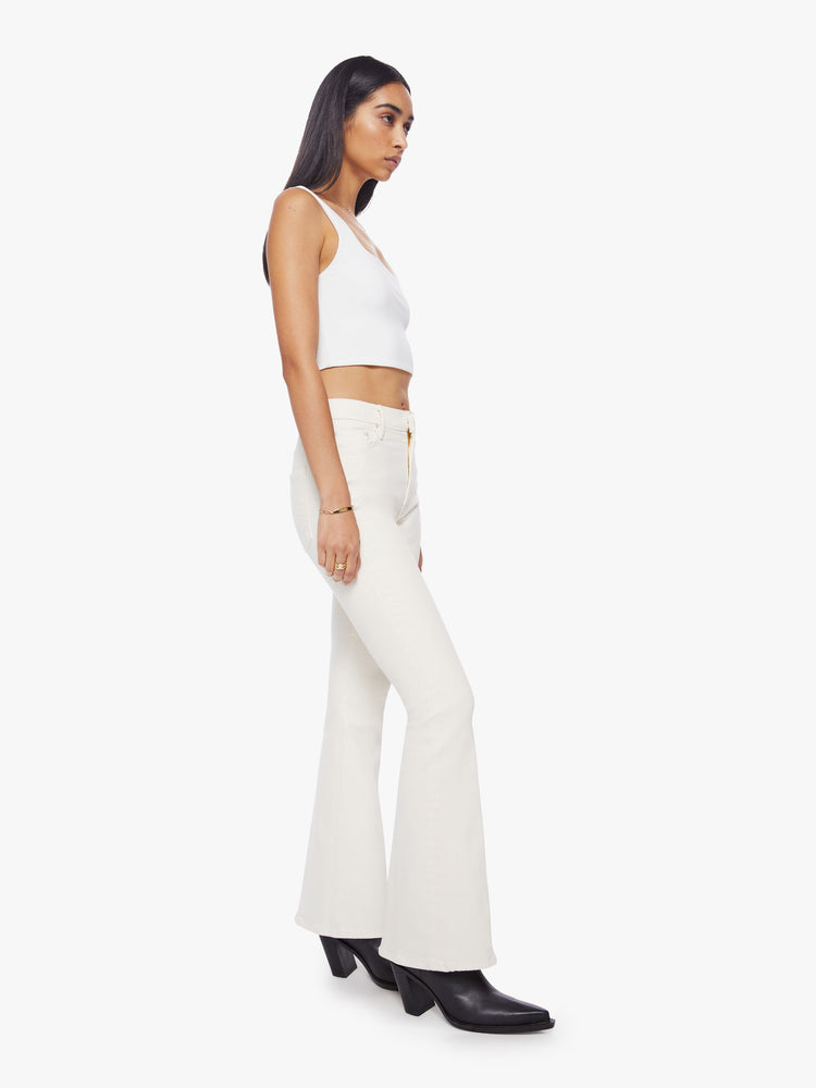 Side angle view of off white hue high rise flare with  long 31-inch inseam and clean hem.