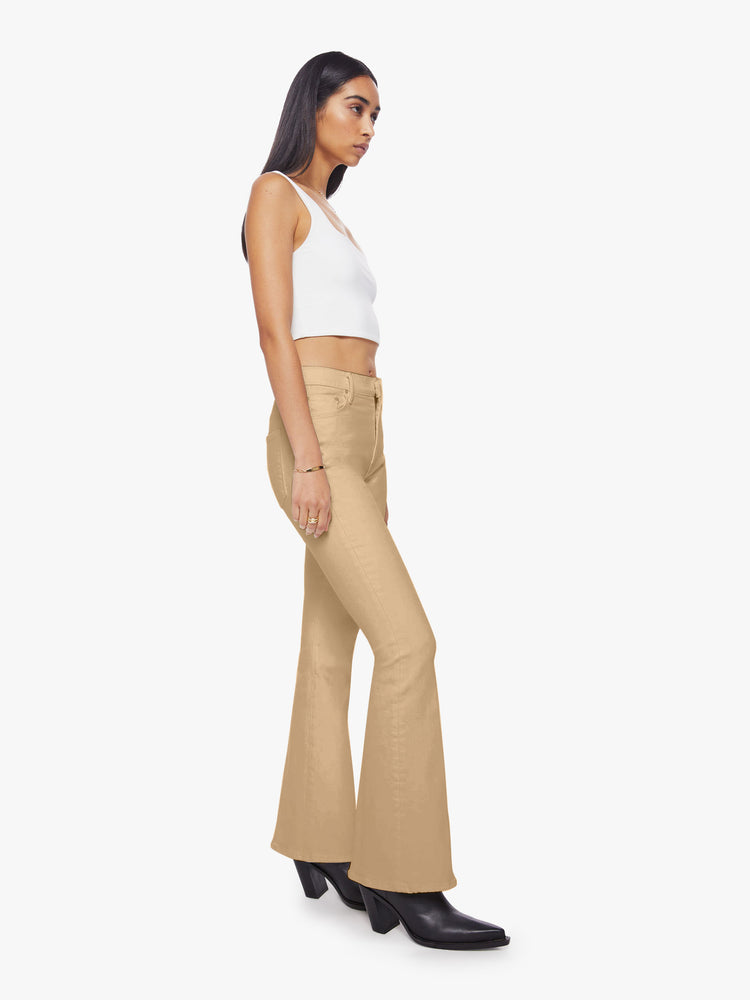 Side angle view of woman sandy hue flare with long 31-inch inseam and clean hem.