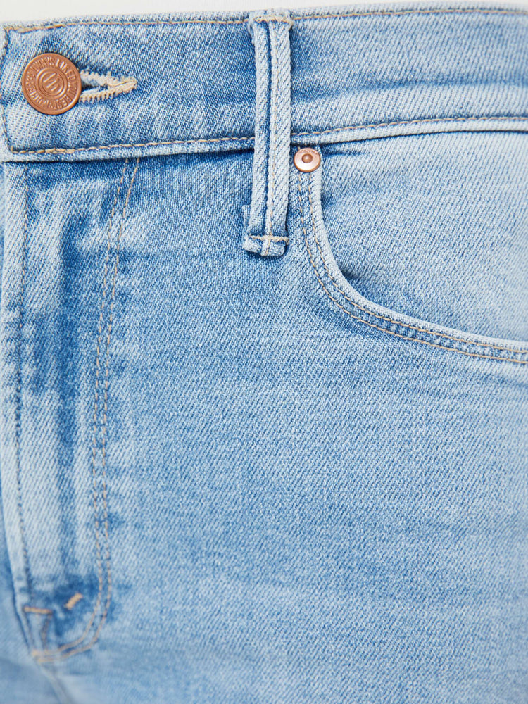 Swatch view of a woman in a med blue mid-rise straight leg hits at the ankle with a frayed hem.