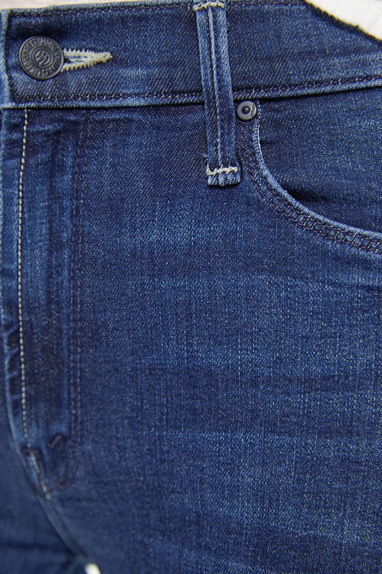 Swatch view of a woman in a dark blue  mid-rise straight leg jean that hits at the ankle with a frayed hem. 