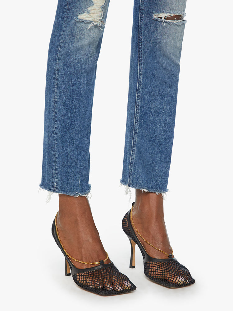 CLOSE UP HEM VIEW OF MID RISE, ANKLE LENGTH STRETCH JEANS WITH FRAYED HEM, WHISKERING, AND DISTRESSED THROUGHOUT