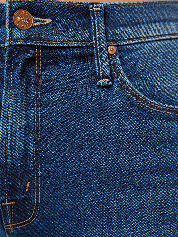 Swatch view of a woman in  dark blue mid-rise straight leg hits at the ankle with a frayed hem.