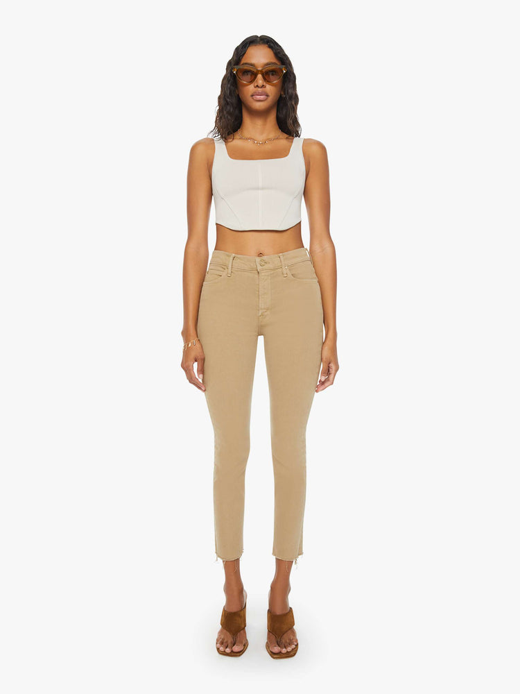 Front view of a womens brown pant featuring a mid rise and a straight leg with a frayed hem.