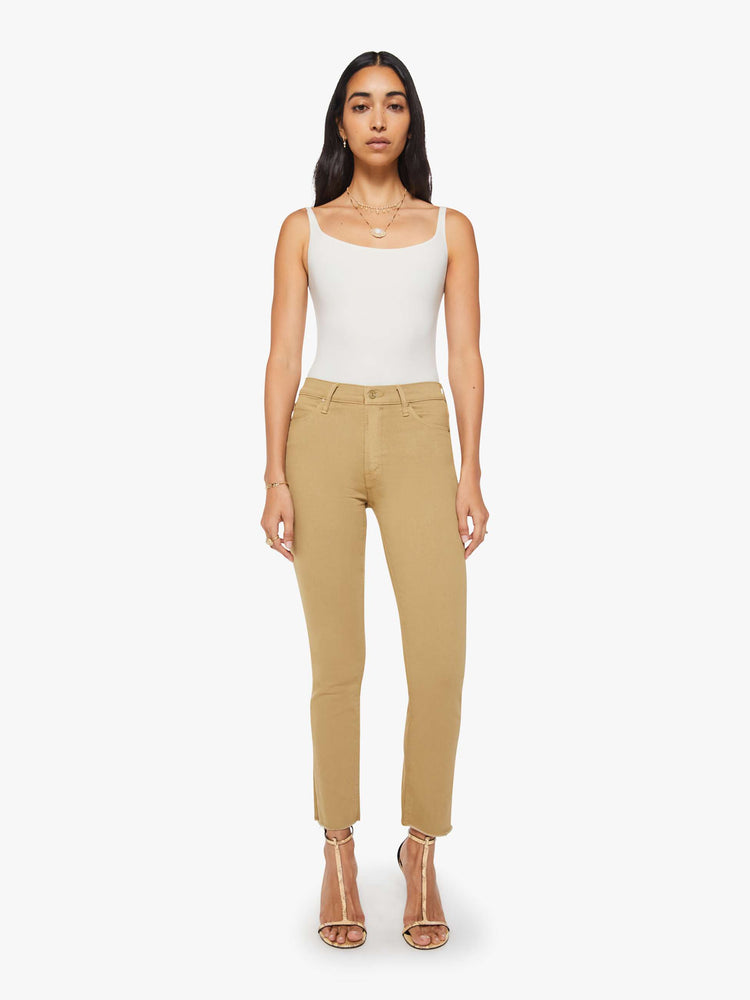 Front view of a woman in a light khaki mid-rise straight leg hits at the ankle with a frayed hem.