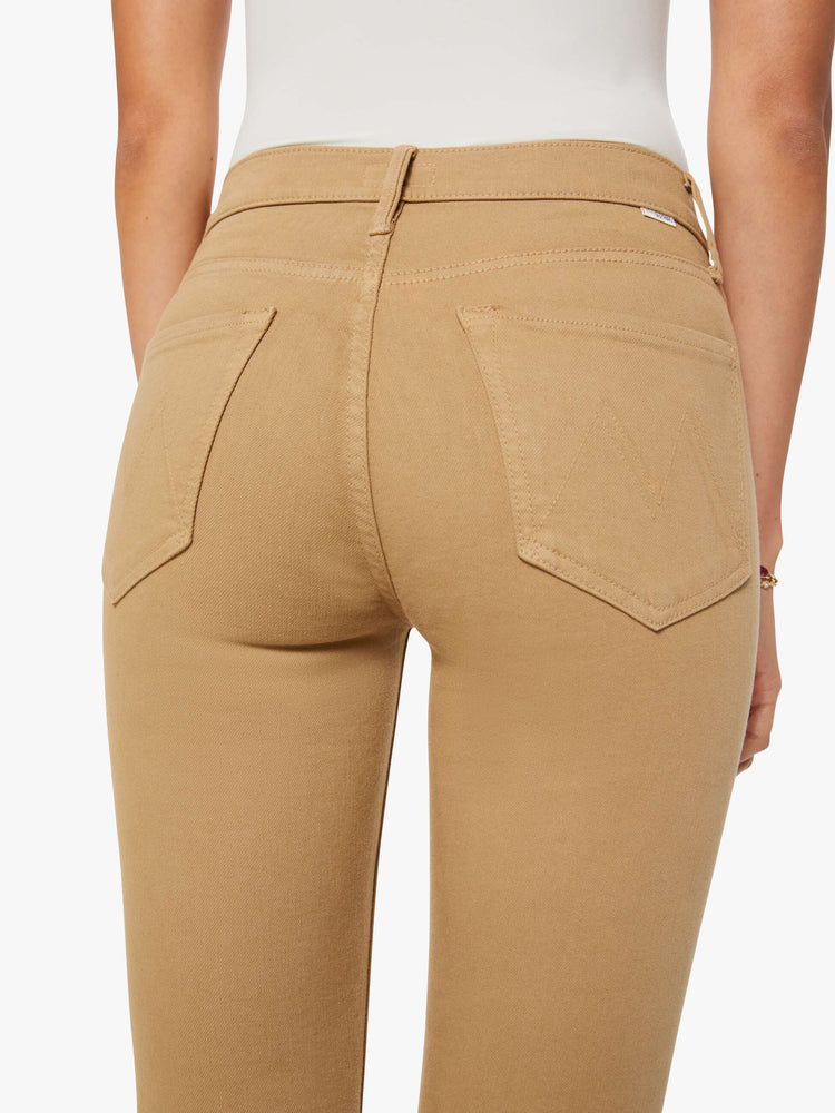 Close up view of a woman in a light khaki mid-rise straight leg hits at the ankle with a frayed hem.