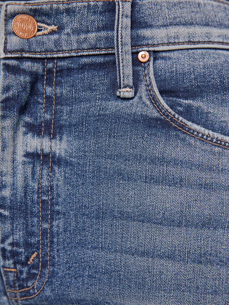 Swatch  view of a medium blue flare with distressed knees and a long clean hem.