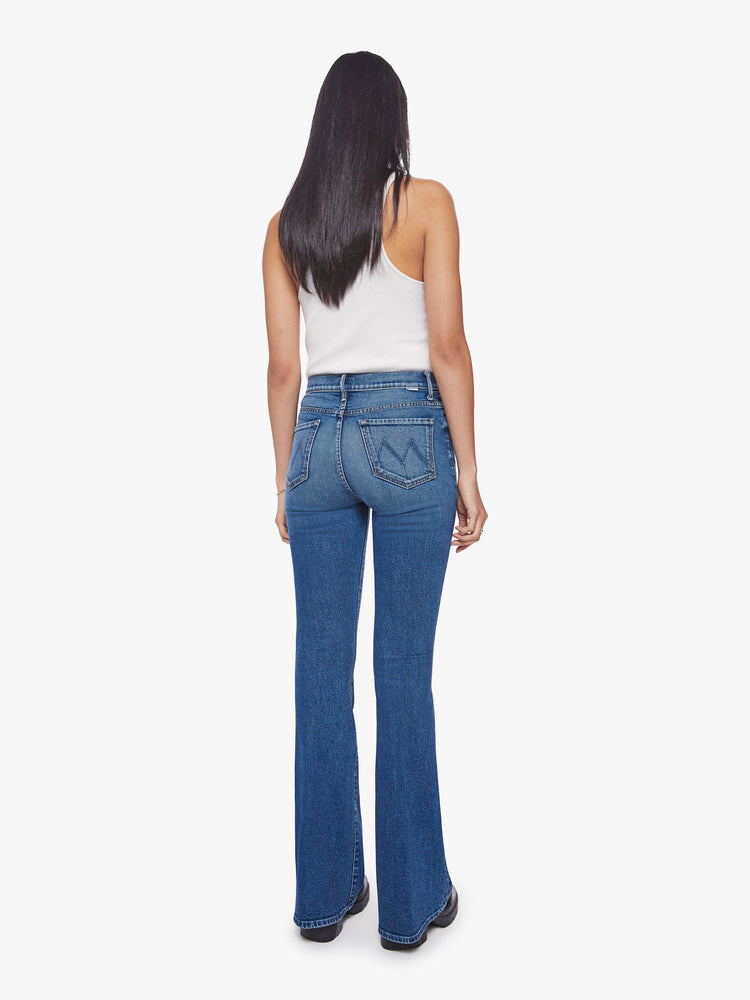 Back view of a woman high-rise flare with a long 34.5-inch inseam and a clean hem in a classic blue hue.
