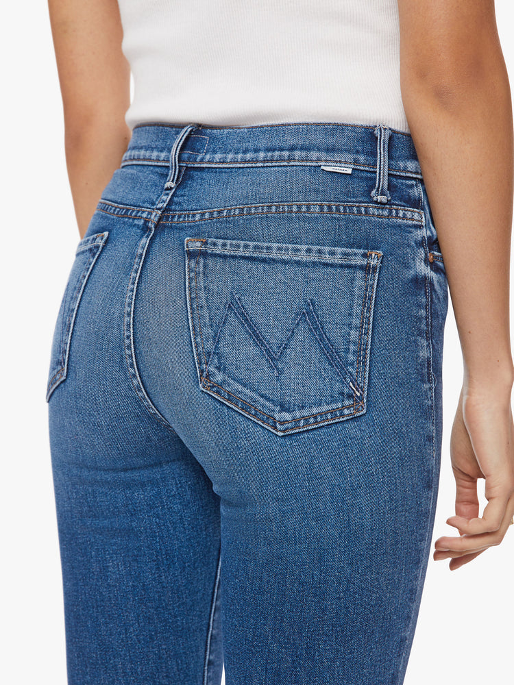 Close up back view of a woman high-rise flare with a long 34.5-inch inseam and a clean hem in a classic blue hue.