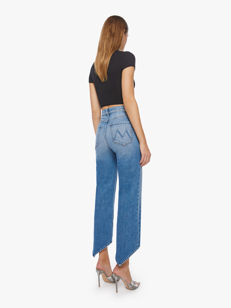 Back view of a woman super high-waisted straight-leg jeans with a V-shaped back hem and a shorter hem in the front in a light blue wash.