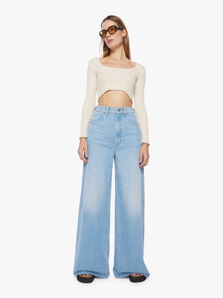 Front view of a woman super high-waisted jeans feature a loose, full leg and a long 34-inch inseam in a light blue wash.