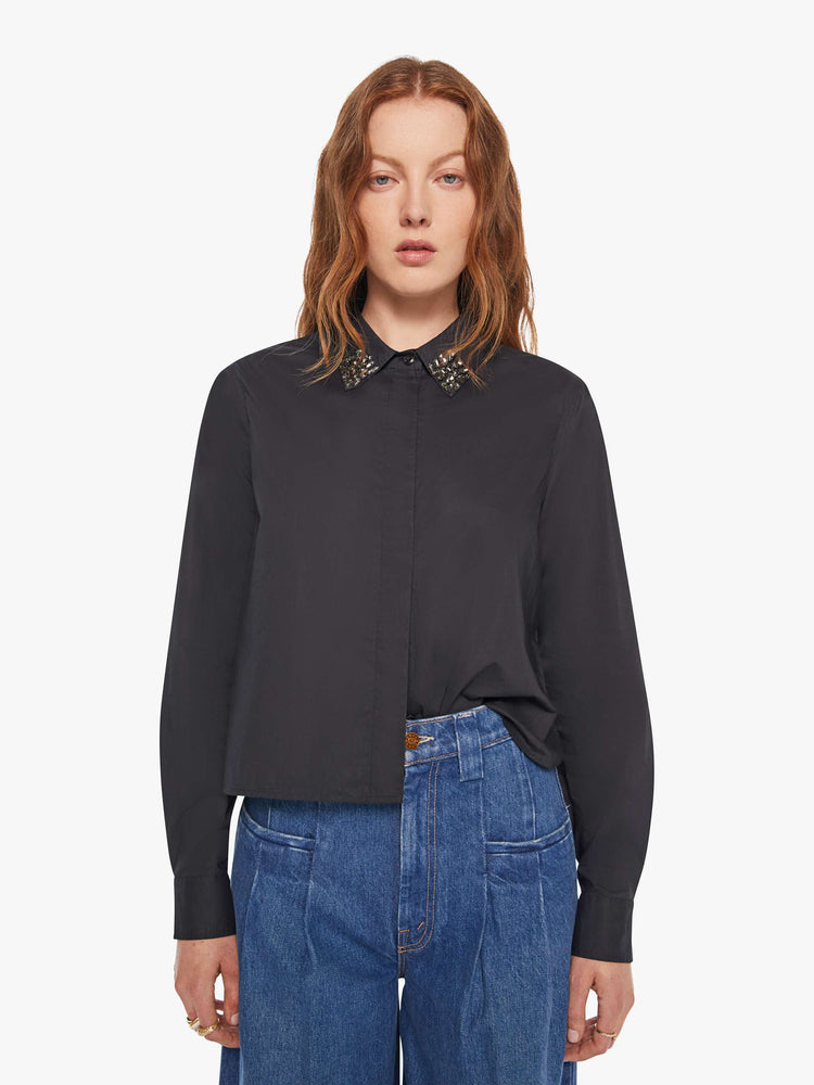Front view of a woman in a black button up with an embellished collar.