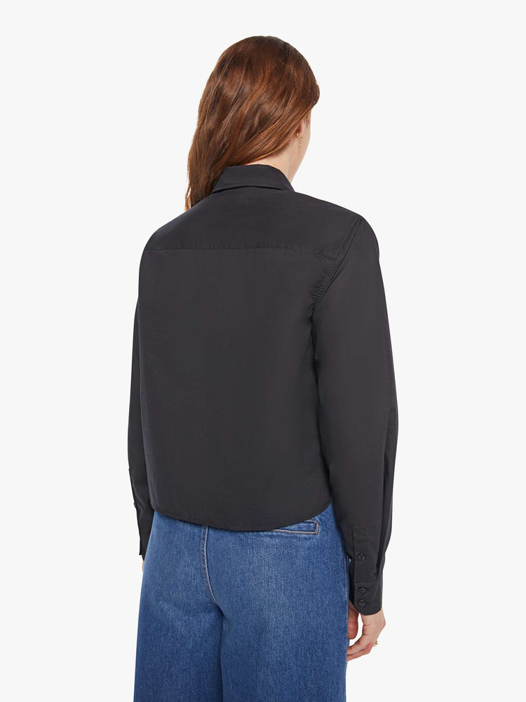 Back view of a woman in a black button up with an embellished collar.