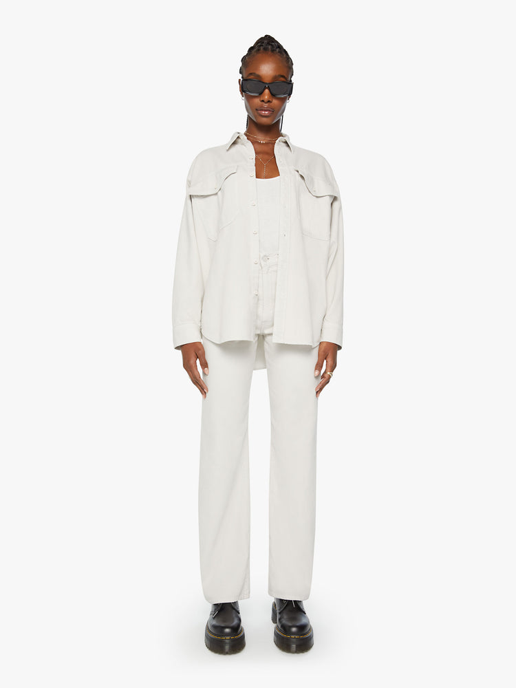 Full body view of a woman oversized button-up with drop shoulders, patch pockets and a curved hem in an off white hue.