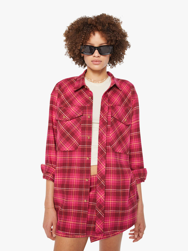 Front view of a woman in a hot pink oversized button-up with drop shoulders, patch pockets and an extra-long curved hem.