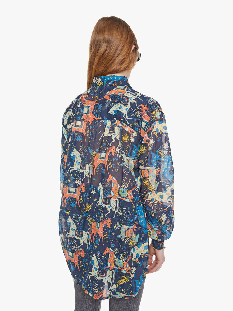 Back view of a woman in a horse print button-up blouse with long balloon sleeves and an extra-long hem.