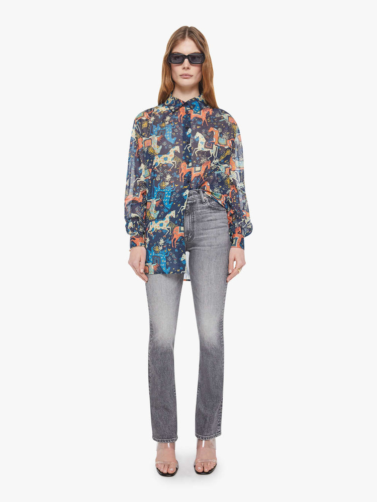 Full body view of a woman in a horse print button-up blouse with long balloon sleeves and an extra-long hem.