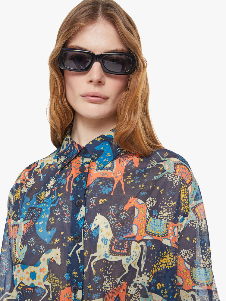 Close up view of a woman in a horse print button-up blouse with long balloon sleeves and an extra-long hem.