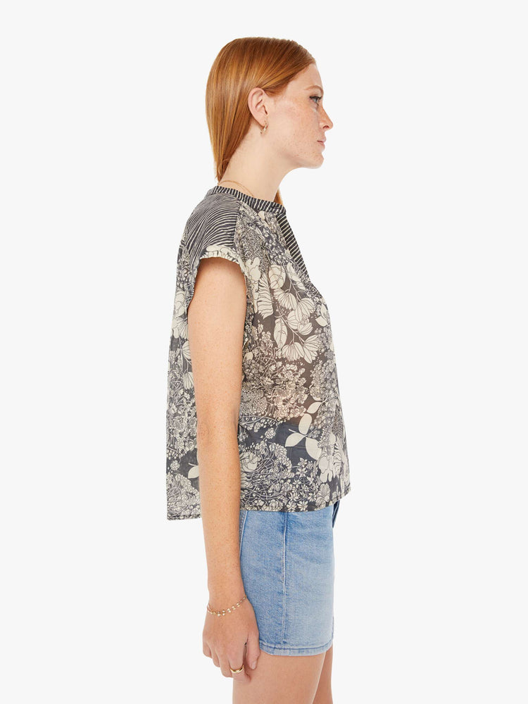 Side view of a black and white floral print button down blouse with a boxy fit.