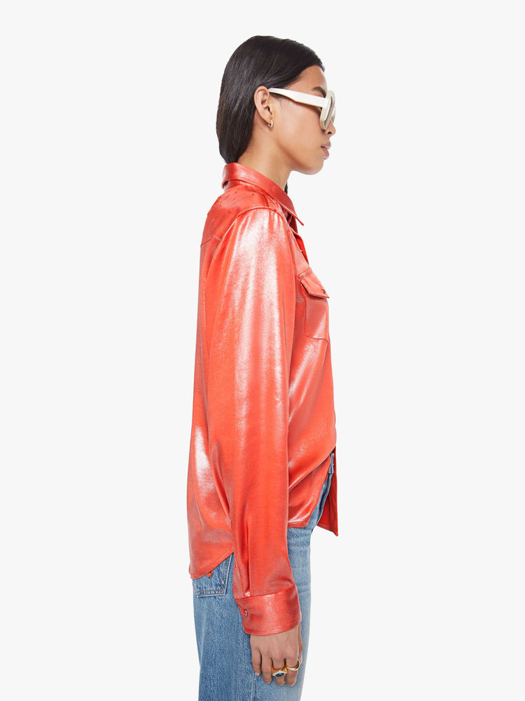 Side view of a woman in red foil denim button-up with front patch pockets and a curved hem.
