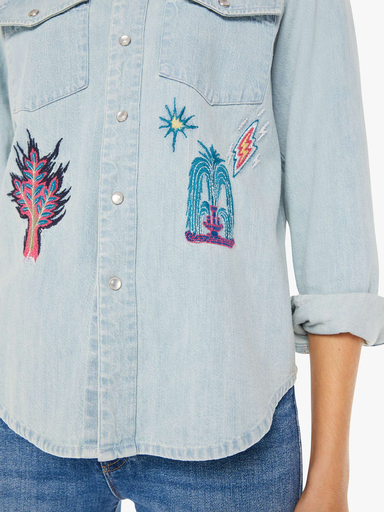 Front detail view of a womens denim shirt featuring embroidered details.