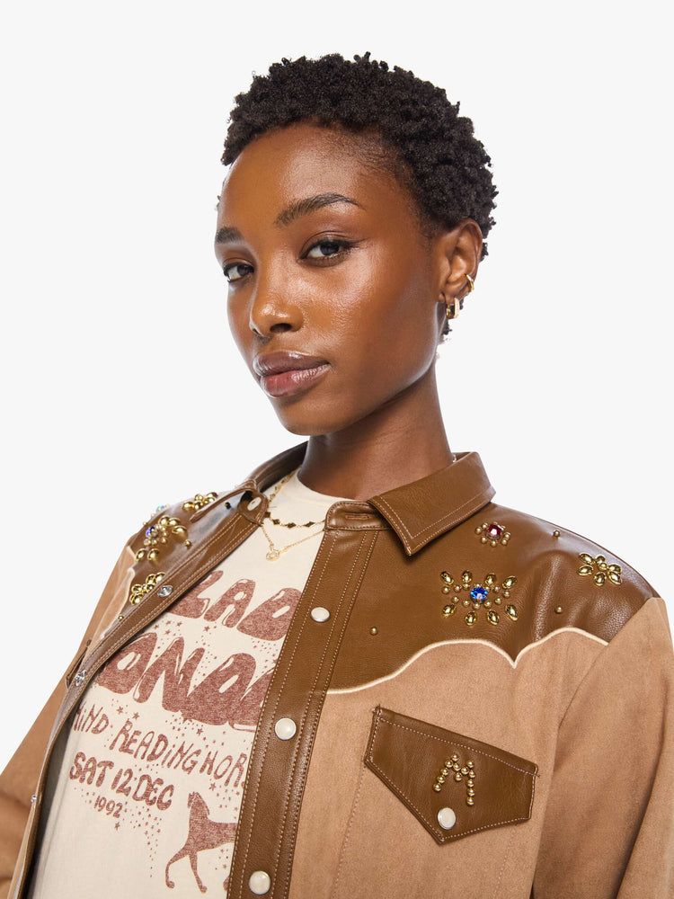 Close up view of a woman faux suede and faux leather with studs and gemstone details button-up with a decorative yoke, patch pockets at the chest, snap closures and a curved hem. 