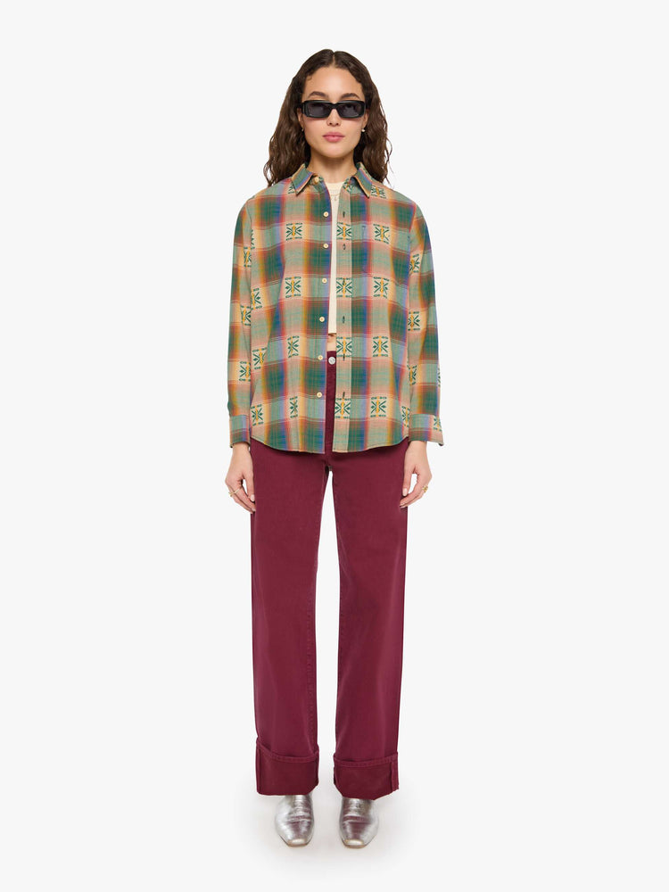 Full body view of a woman in  plaid with embroidered details throughout button up.