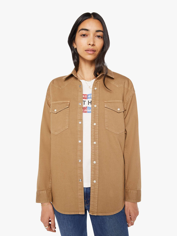 Front view of a woman in khaki denim button-up with drop shoulders, front patch pockets, a Western-inspired yoke and a curved hem.