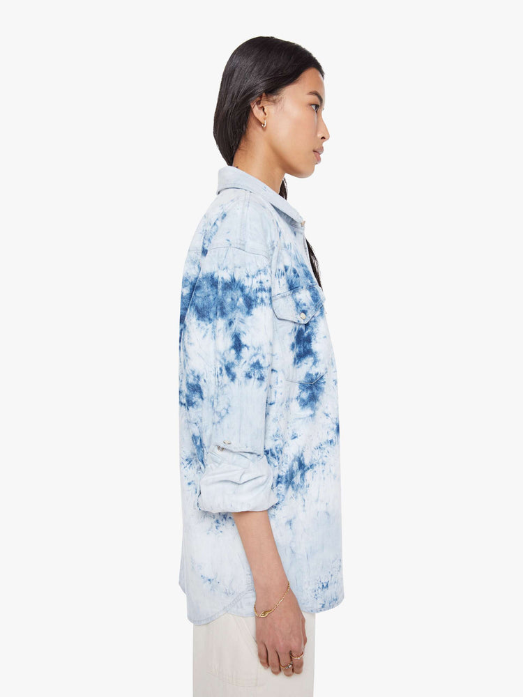 Side view of a bleached tie die oversized button-up with drop shoulders, front patch pockets, a Western-inspired yoke and a curved hem.