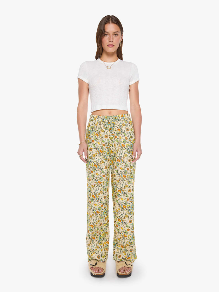Pant view of woman in two-piece pajama set includes a collared, long-sleeve button-up blouse with a patch pocket and boxy fit, and loose, wide-leg pants with slit pockets and an elastic hem.