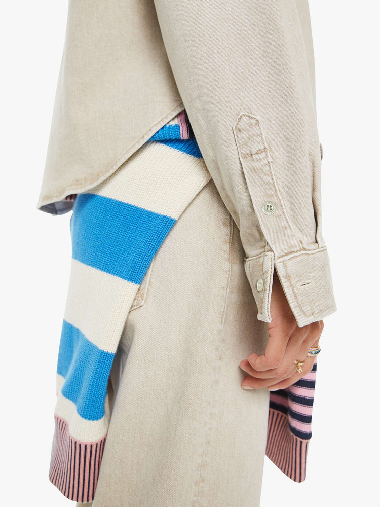 Close up view of a woman in faded khaki  button-up denim top with a front patch pocket and a curved, cropped hem.