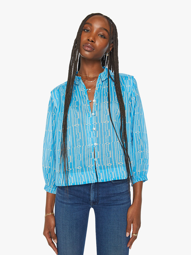 Front view of a woman collared button-up blouse with extra-wide shoulder seams, 3/4-length balloon sleeves and a slightly cropped hem in a light blue with white pattern.