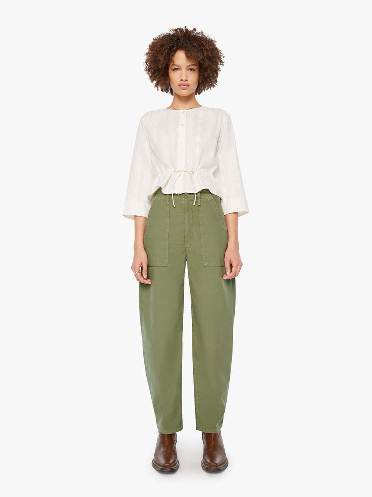 Full body view of woman in a white 3/4-length sleeves blouse, a tied waist, buttons down the front and a slightly cropped fit.