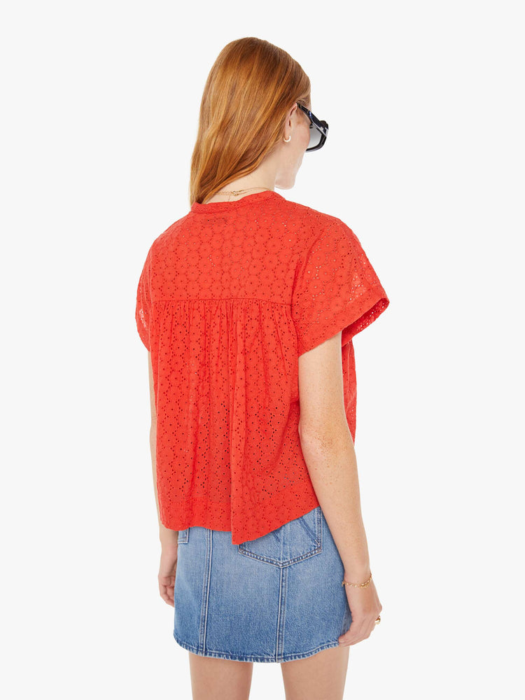 Back view of a woman red lightweight blouse with a buttoned V-neck, short boxy sleeves and ruffles across the chest for a loose, flowy fit.