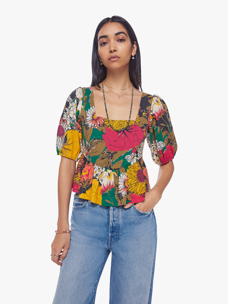 Front view of woman square-neck blouse with elbow-length balloon sleeves and a ruffled peplum hem in an oversized floral print.