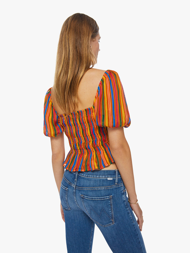 Back view of a womens top featuring a multi color stripe print, a square neckline, balloon short sleeves, and a smocked bodice.