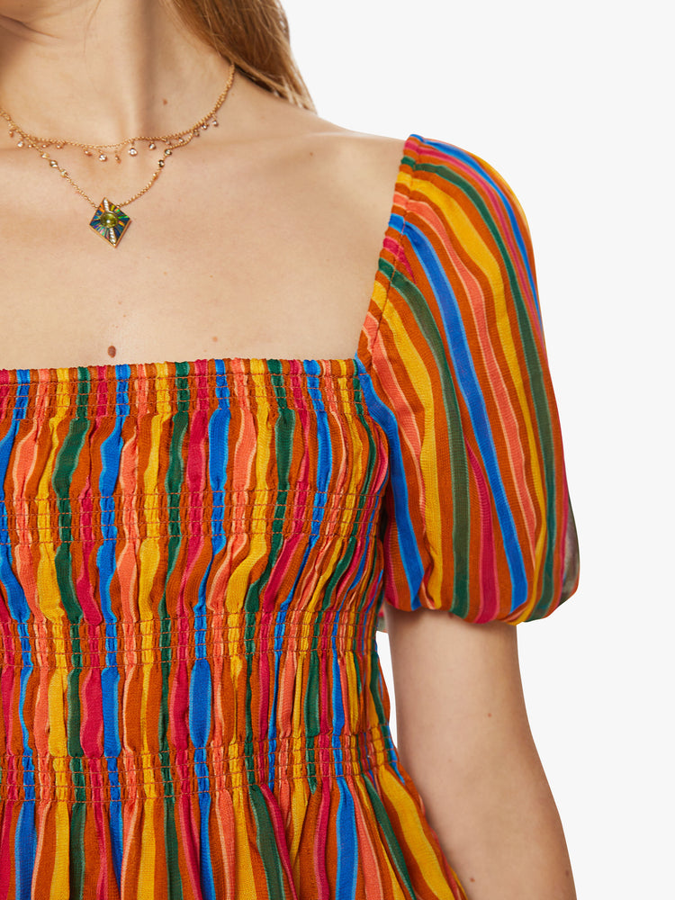 Front detail view of a womens top featuring a multi color stripe print, a square neckline, balloon short sleeves, and a smocked bodice.