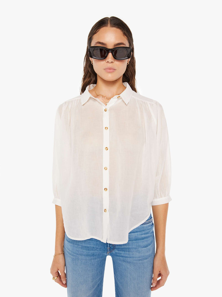 Front view of a woman white lightweight collared blouse with 3/4-length balloon sleeves, a curved hem and ruffles throughout for a flowy fit.