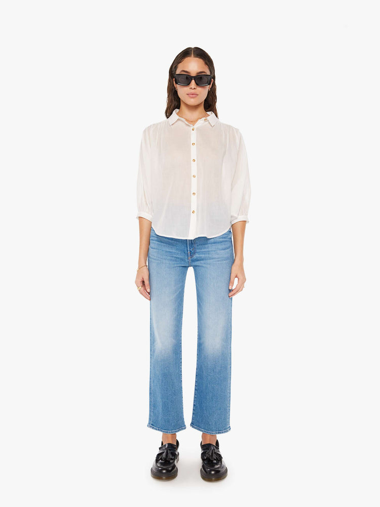 Full body view of a woman white lightweight collared blouse with 3/4-length balloon sleeves, a curved hem and ruffles throughout for a flowy fit.