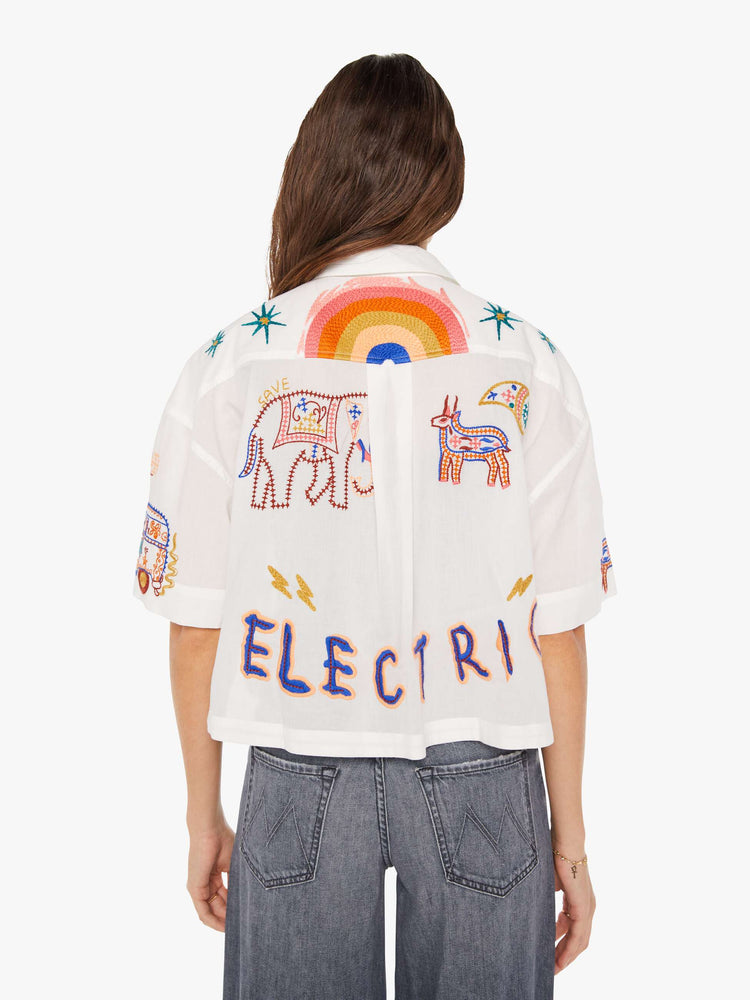 Back view of a womens white button down shirt featuring short sleeves and embroidery throughout.