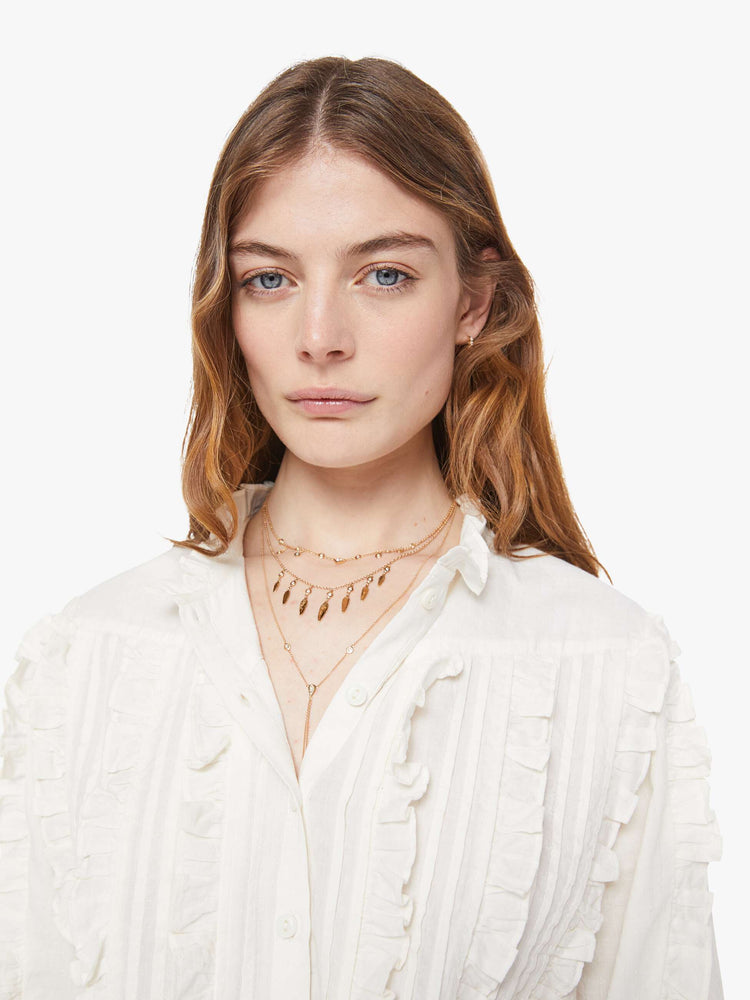 Close up view button-up blouse with long sleeves, slightly dropped shoulders and a boxy fit.