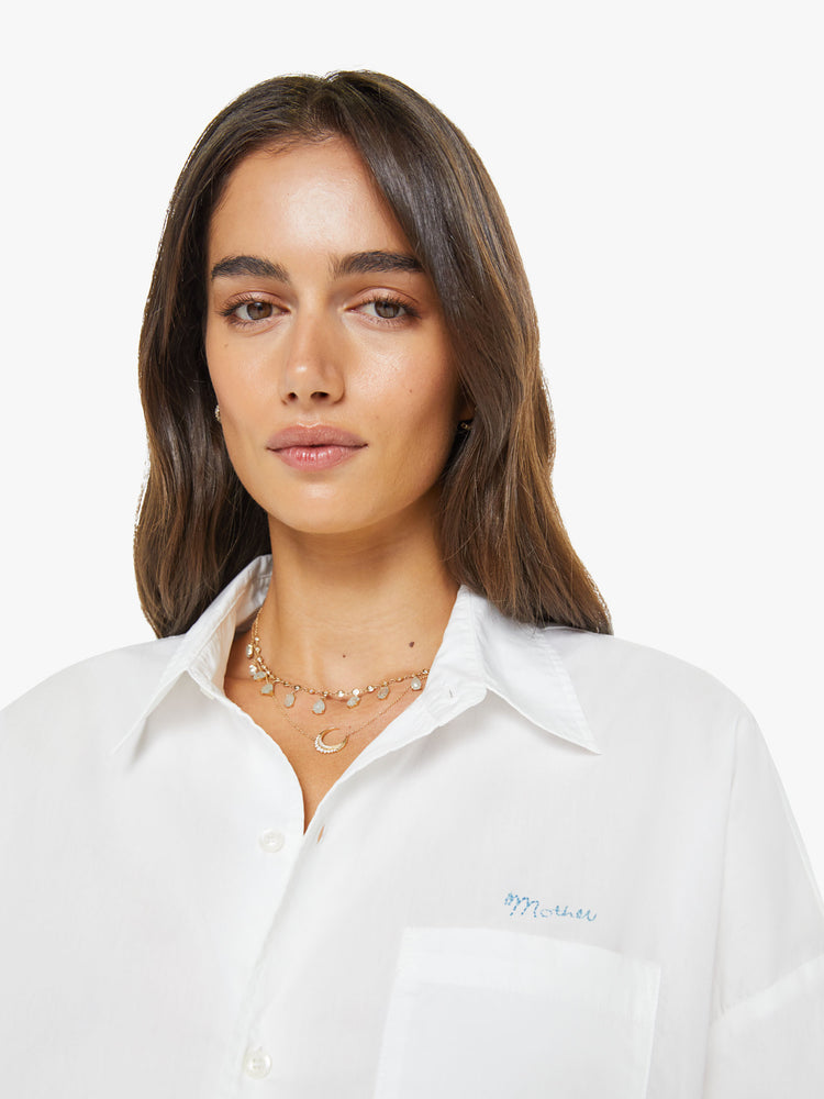 Close up view of woman in a white cropped button-up with long wide sleeves and a bubble hem.