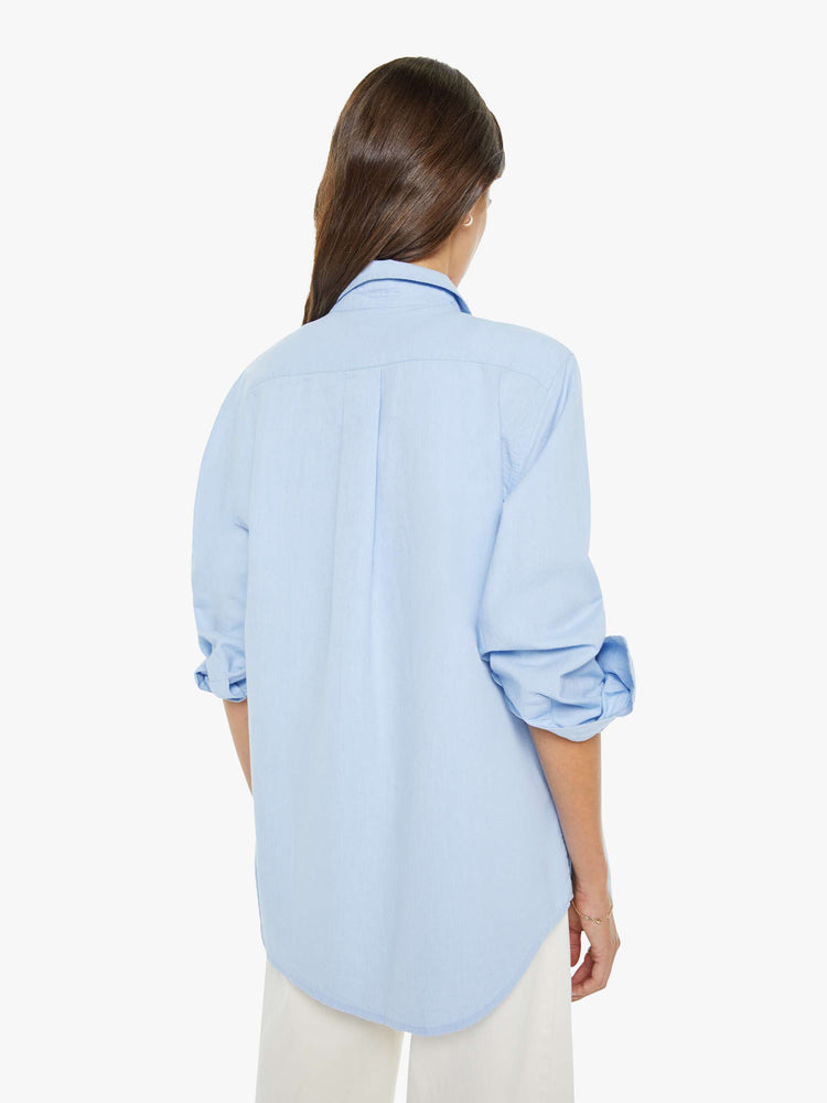 Back view of  woman in a light blue classic button-up with a curved hem and MOTHER's name embroidered on the chest.