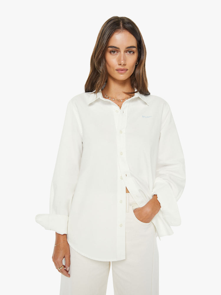 Front view of a woman in a white classic button-up with a curved hem and MOTHER's name embroidered on the chest.