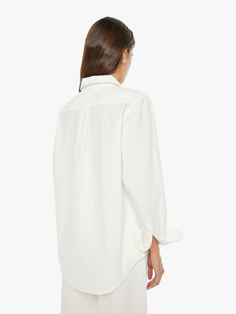 Back view of a woman in a white classic button-up with a curved hem and MOTHER's name embroidered on the chest.