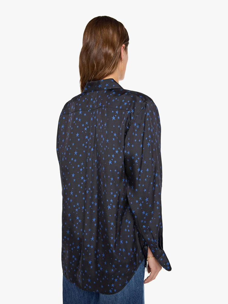 Back view of a woman in a black with navy stars throughout classic button up. 