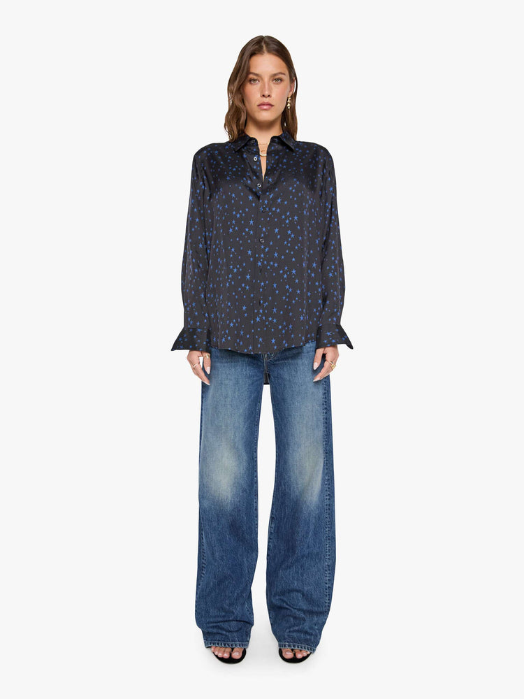 Front view of a woman in a black with navy stars throughout classic button up. 