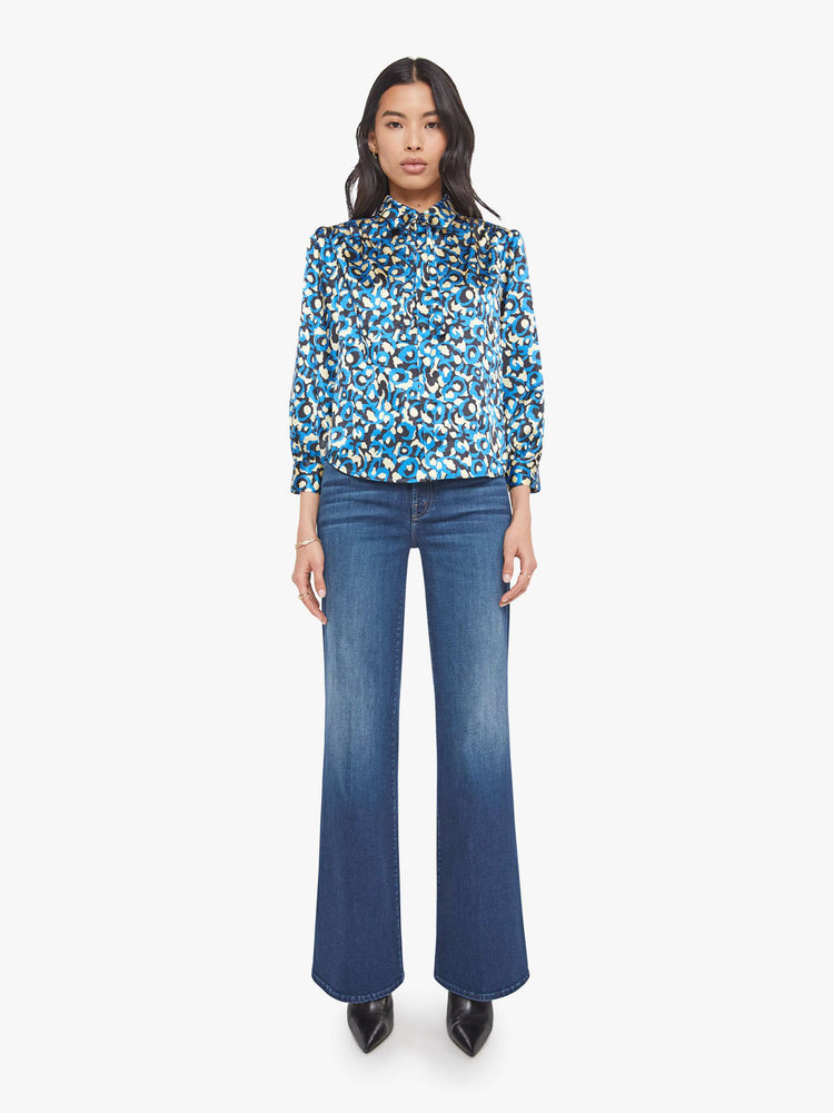 Front full body view of a woman in a collared button-up blouse with puff shoulders, cropped sleeves and a slightly curved hem.