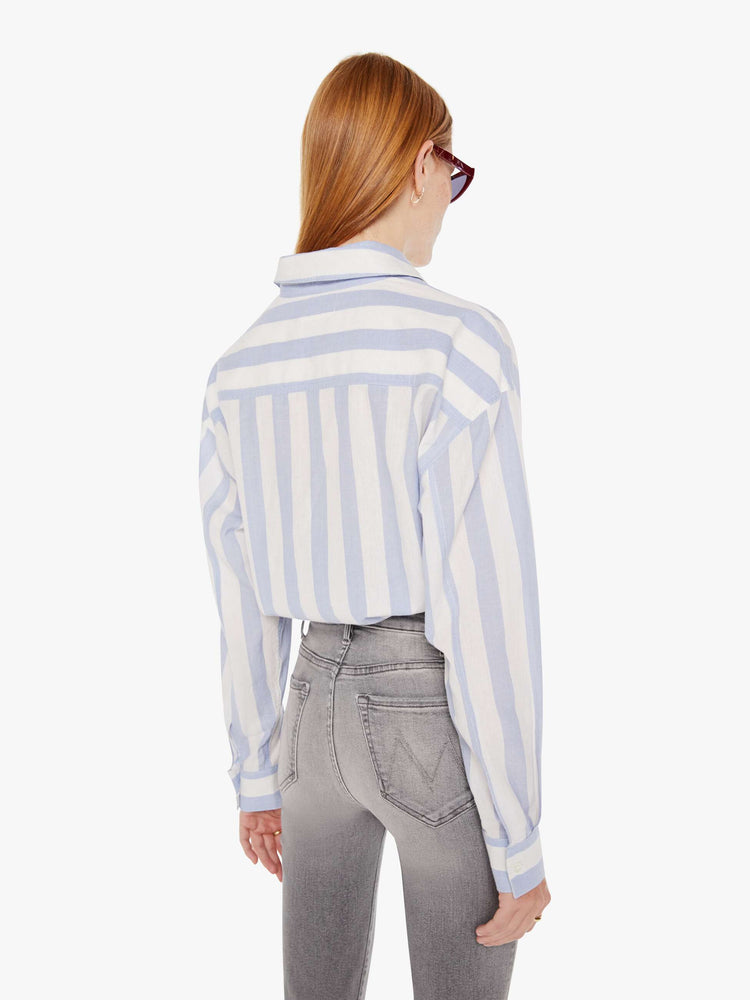 Back view of a womens button down shirt featuring a white a light blue stripe pattern and a cropped waist tie.